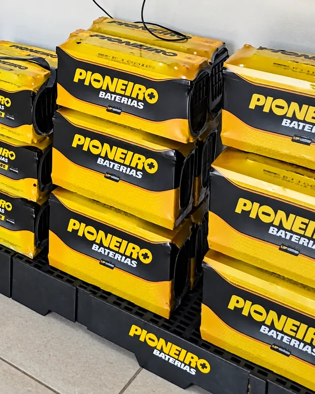Pilhas de baterias Pioneiro amarelas e pretas sobre um palete no estoque da loja