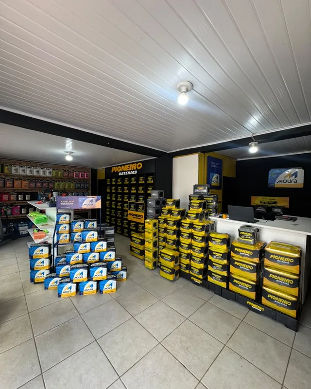 Interior da loja com pilhas de baterias Moura e Pioneiro e o balcão de atendimento